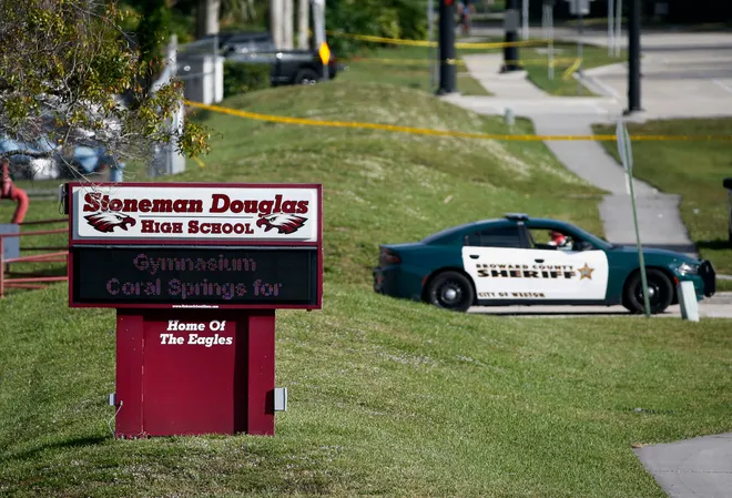 In this Feb. 15, 2018, file photo, law enforcement officers block off the entrance to Marjory Stoneman Douglas High School in Parkland, Fla., following a deadly shooting at the school. Wilfredo Lee, AP