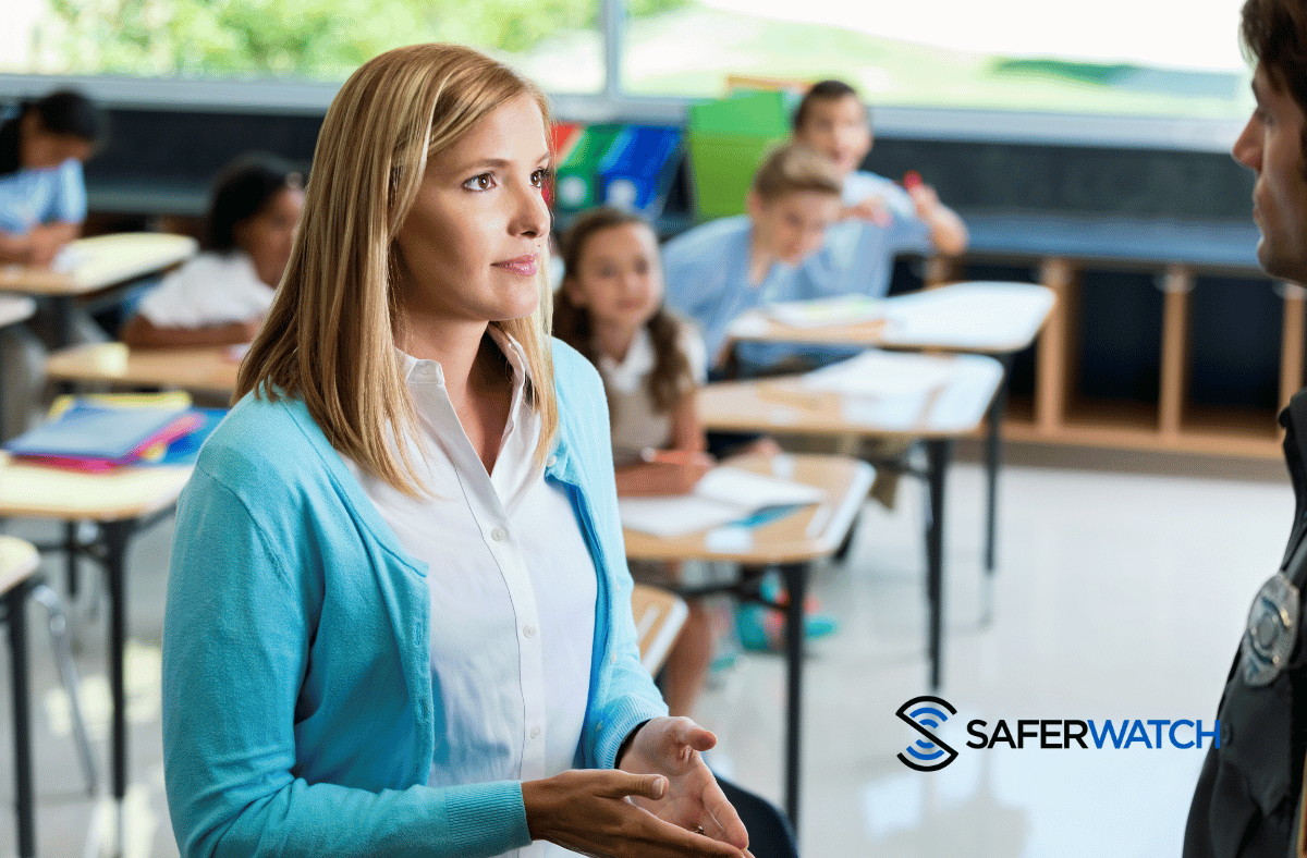 Officer discussing safety with a teacher in a class room - SaferWatch