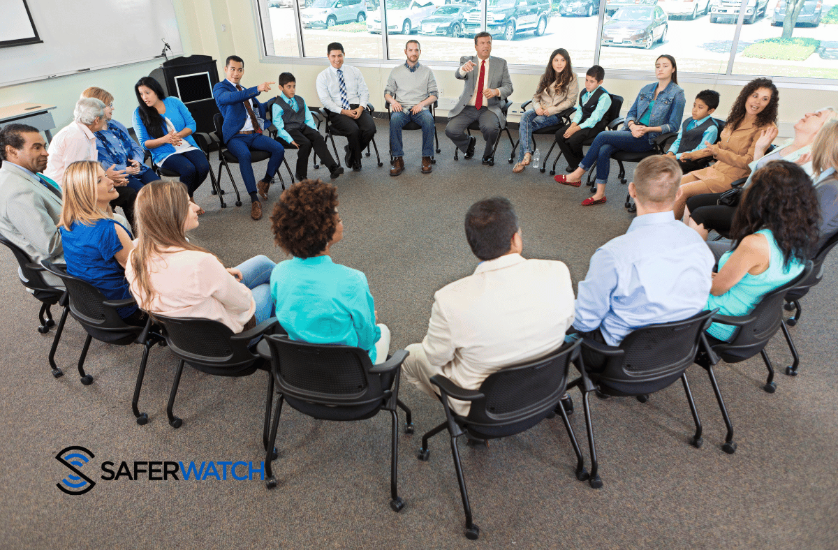 Group of teachers discussing safety in a circle - SaferWatch