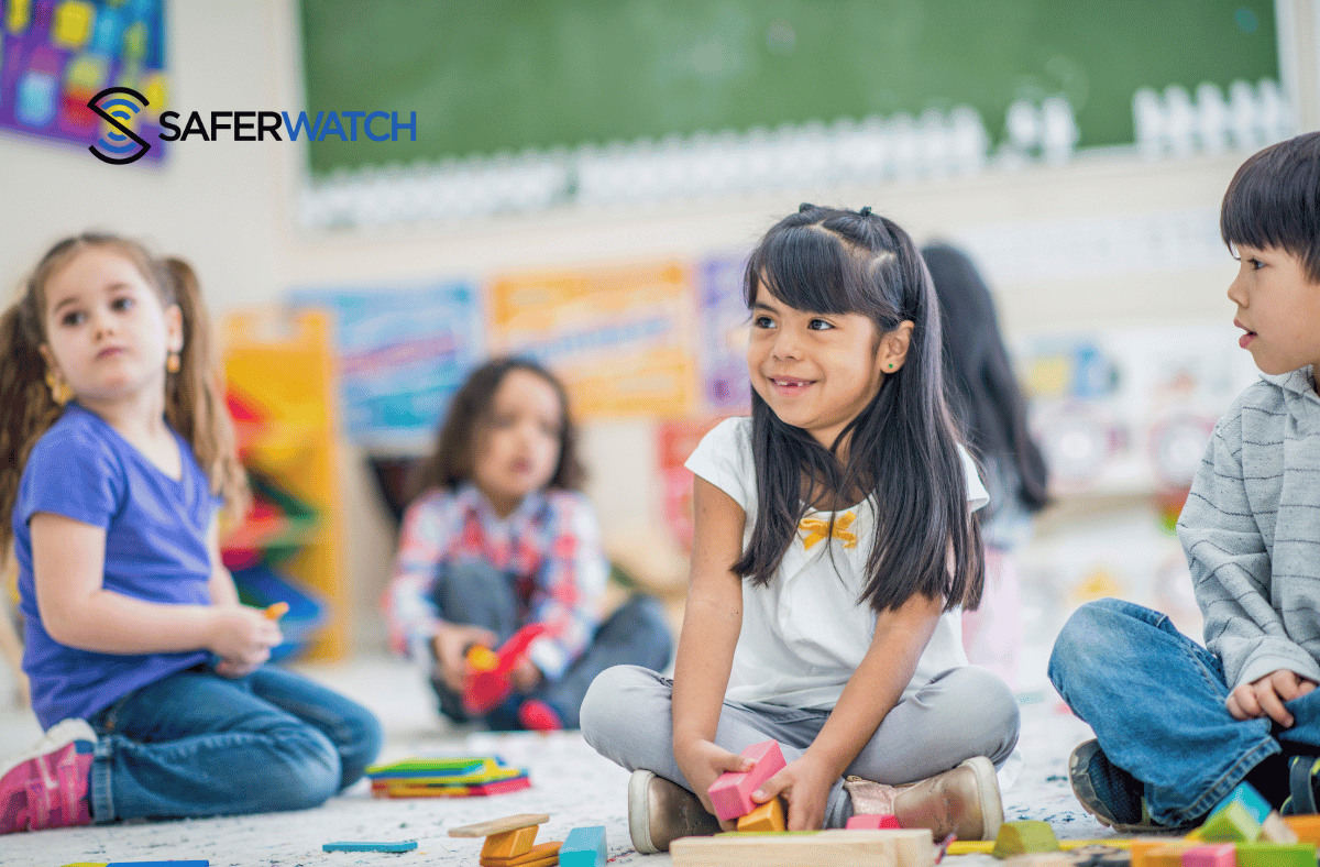 group of young students sitting on the floor in a classroom - SaferWatch