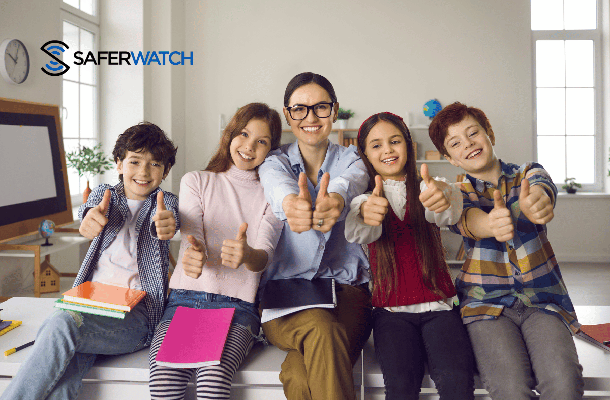 teach and students happy in a class room - SaferWatch